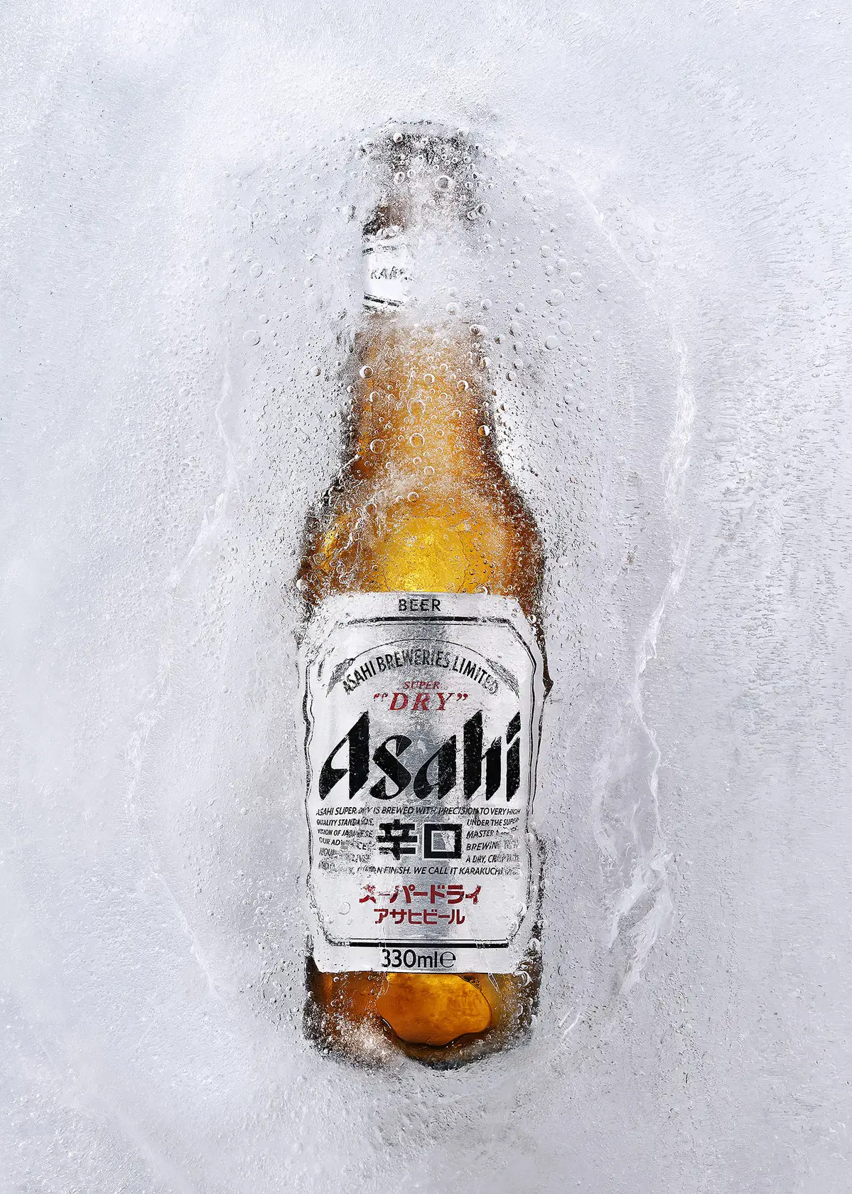 Asahi beer bottle bursting through cracked ice and vapor